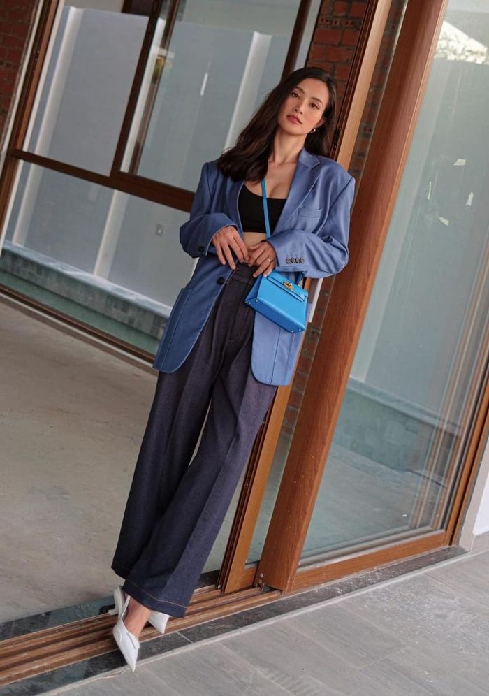 Đông Nhi duyên dáng trong chiếc blazer màu xanh lam cùng quần ống rộng. Nữ ca sĩ khéo kết hợp với áo bra màu đen tương phản tôn vòng eo thon mà khiến bộ cánh không trở nên đơn điệu. Chiếc túi xách hàng hiệu mang tông xanh sáng màu khiến cả tổng thể vốn trung tính trở nên bừng sáng và cuốn hút hơn.
