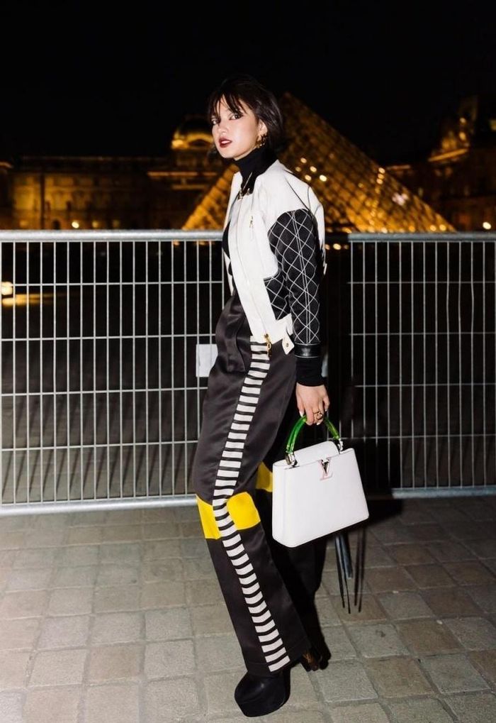 Châu Bùi thời thượng khi kết hợp áo biket jacket cùng quần ống suông. Họa tiết cùng gam màu bộ cánh hoàn chỉnh cho một tổng thể thống nhất. Nữ người mẫu lựa chọn túi xách mới nhất từ thương hiệu Louis Vuitton đồng thời trang điểm sậm màu hài hòa.