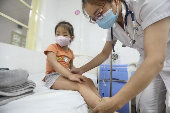Bác sĩ khám cho bệnh nhi sốt xuất huyết tại bệnh viện Thanh Nhàn. Ảnh: Minh Quyết - TTXVN