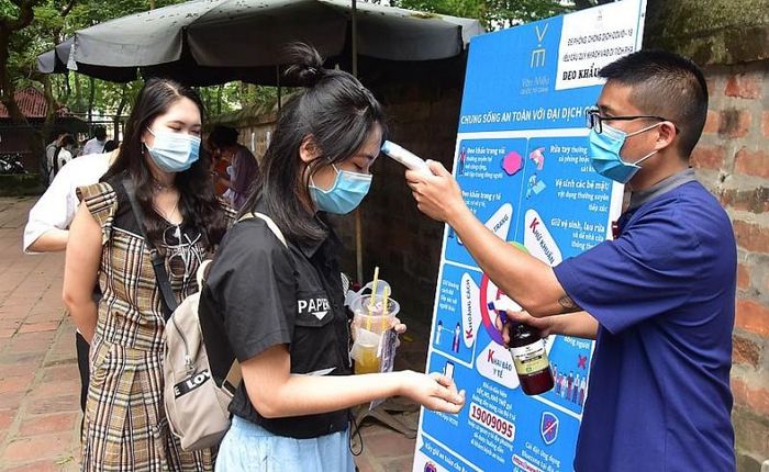 Kiểm tra thân nhiệt của du khách trước khi vào tham quan Văn Miếu - Quốc Tử Giám, tháng 4/2021. (Nguồn: Báo Hà Nội Mới)