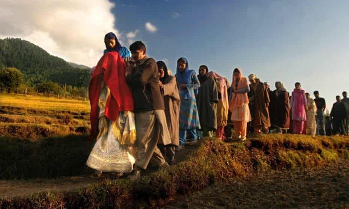 Một cô dâu Kashmir khoác trên mình chiếc khăn choàng đỏ, đồng hành cùng gia đình và bạn bè đến nhà chú rể để bắt đầu buổi lễ