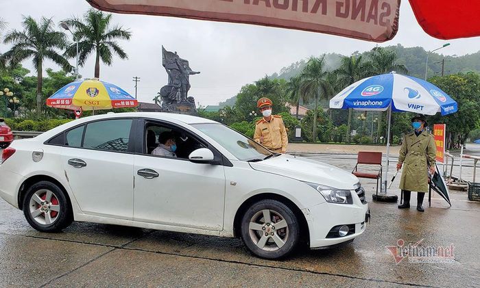 Tài xế vẫn xuất trình giấy tờ khi qua chốt kiểm soát cầu Bến Thủy nhưng được lực lượng làm nhiệm vụ ra tín hiệu di chuyển. Ảnh: Quốc Huy