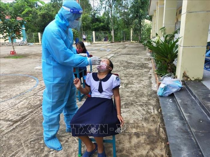 Lấy mẫu xét nghiệm COVID-19 cho học sinh, giáo viên tại Trường Tiểu học Thạnh An. Ảnh: TTXVN phát