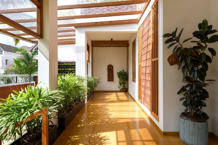 Bên hông tầng 1 là phần hành lang ngoài trời còn bên hông tầng 2 là ban công mở giúp thiên nhiên có thể đến gần với người trong nhà hơn. Bên hiên có thêm màn che chống nắng giúp giảm bớt cái nóng vào ban ngày và tránh cho mưa gió tạt thẳng vào nhà.