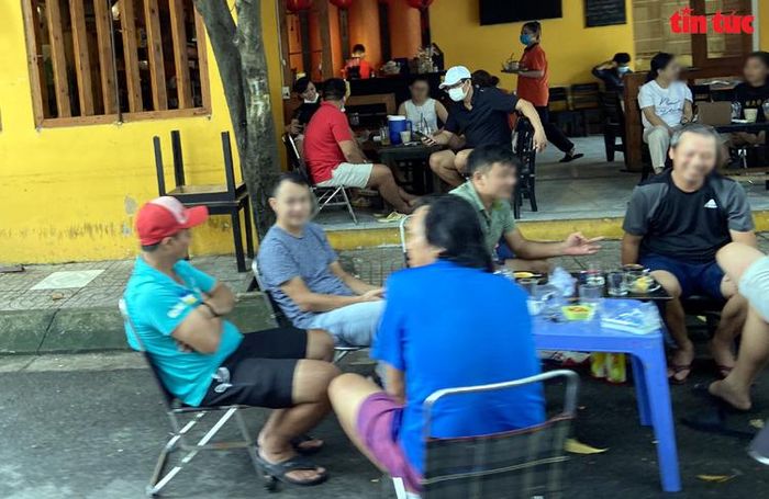 Vào ngày cuối tuần, các quán cà phê ở phường Tân Thành (quận Tân Phú, TP Hồ Chí Minh) chật kín khách từ trong ra ngoài, nói chuyện vô tư và không đeo khẩu trang dù chính quyền TP Hồ Chí Minh vẫn chưa cho phép hàng quán phục vụ tại chỗ. Ảnh: Mạnh Linh/Báo Tin tức