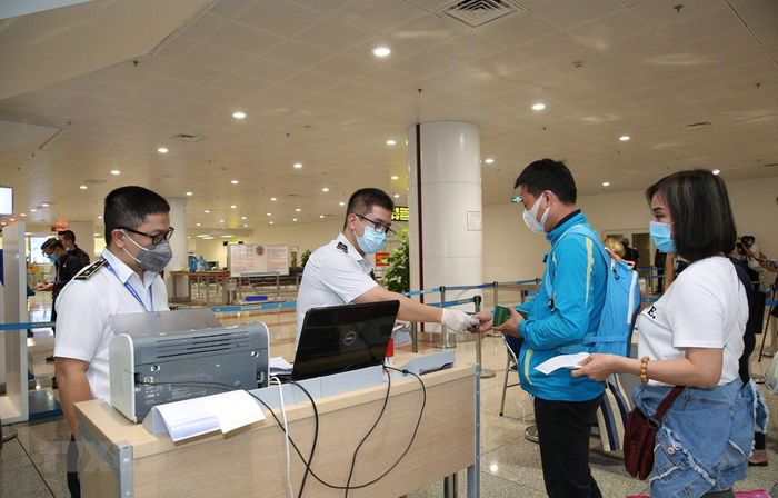 Kiểm tra phiếu khai báo y tế của hành khách tại cửa khẩu Sân bay quốc tế Nội Bài. Ảnh: Dương Giang