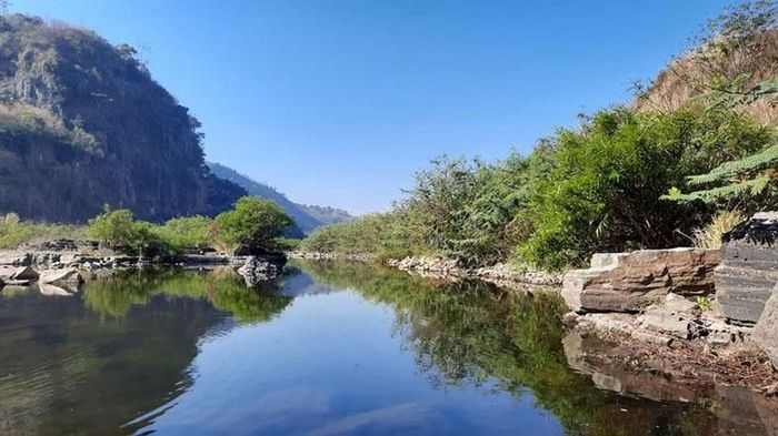 Con suối mát lành với một bên là vách đá dựng đứng, hùng vĩ, nguyên sơ