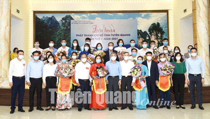 Các đại biểu chụp ảnh lưu niệm với các Đài tham dự Liên hoan nhận cờ lưu niệm của Ban Tổ chức.