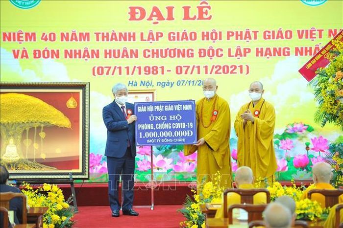 Chủ tịch Ủy ban Trung ương Mặt trận Tổ quốc Việt Nam Đỗ Văn Chiến tiếp nhận bảng tượng trưng tiền từ thiện ủng hộ Quỹ phòng, chống dịch COVID-19 do Giáo hội Phật giáo Việt Nam trao tặng. Ảnh:Minh Đức/TTXVN