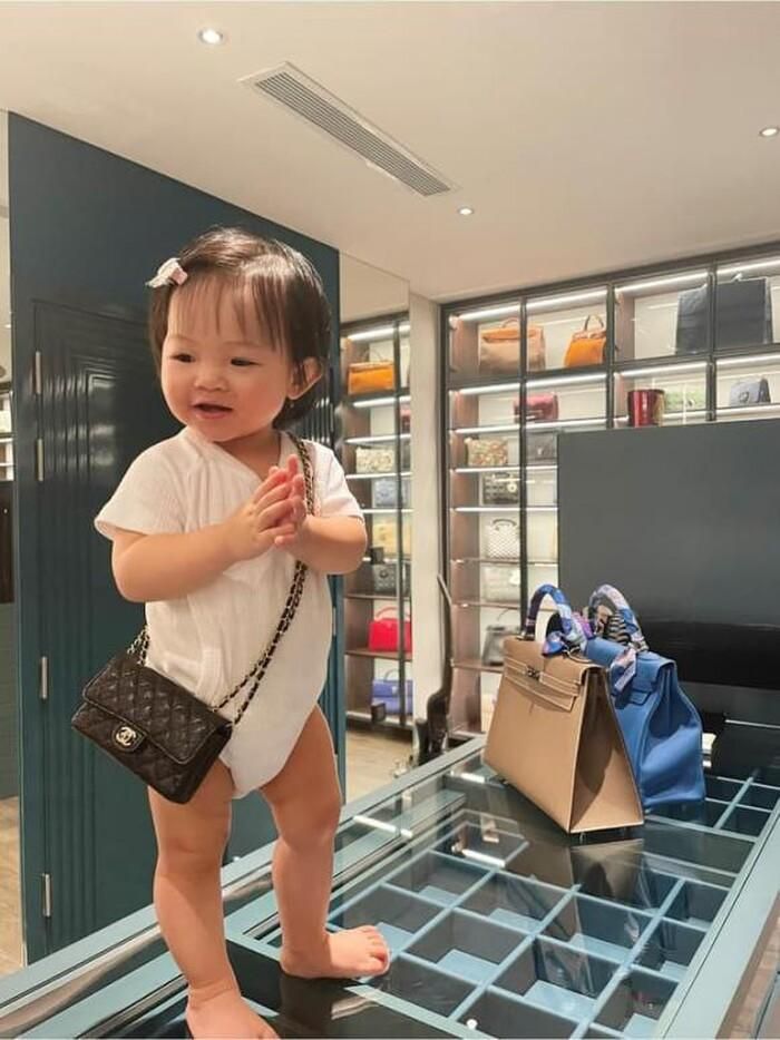 Trong ảnh là Suchin 1 tuổi đang đeo trên người chiếc túi Chanel cỡ nhỏ, đứng chụp hình giữa căn phòng chất toàn đồ hiệu của ba mẹ.