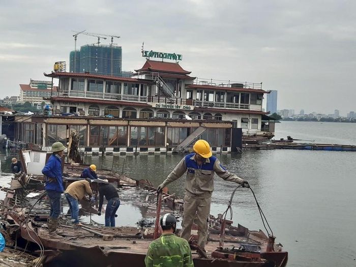  Tại khu vực Đầm Bảy (phường Nhật Tân, Tây Hồ), hàng chục công nhân đang tháo dỡ những chiếc tàu thuyền nổi cuối cùng còn sót lại. 