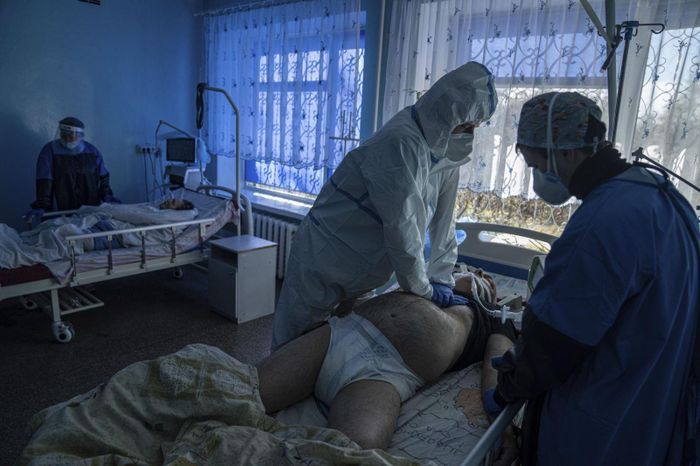Bác sĩ Oleksandr Molchanov (mặc bảo hộ trắng) hô hấp nhân tạo cho bệnh nhân COVID-19 ngày 29/10/2021. Ảnh: AP , second right, and another medical worker perform CPR on a patient at a hospital in Kakhovka, Ukraine, on Friday, Oct. 29, 2021. (AP Photo/Evgeniy Maloletka)