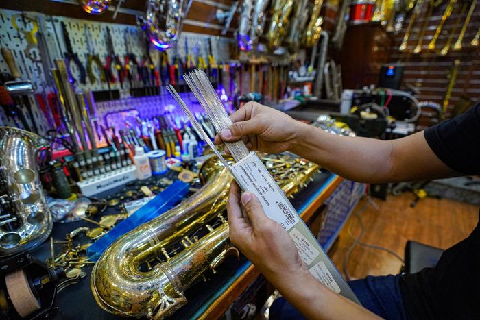 Để sửa chữa, anh Khang nhập linh kiện cả mới lẫn cũ từ những nơi uy tín như Mỹ, Đức, Pháp về xưởng. Cầm trên tay hộp que hàn nhập từ Đức, anh Khang nói: “Đây là loại que hàn đắt nhất trong các loại que, hàn dính đồng với đồng. Một que thế này có giá hơn 200.000 đồng”.