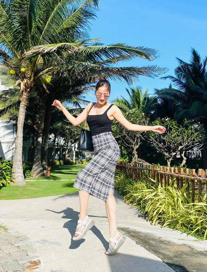 Áo hai dây mỏng manh và chân váy kẻ sọc luôn là combo thời trang được bà xã của Phan Hiển ứng dụng rất nhiều. 