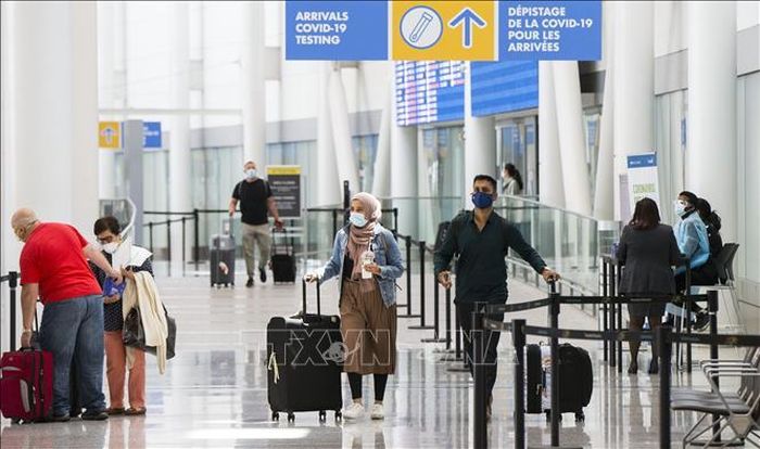 Hành khách đeo khẩu trang phòng lây nhiễm COVID-19 tại sân bay quốc tế ở Ontario, Canada. Ảnh: THX/TTXVN