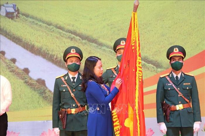 Phó Chủ tịch nước Võ Thị Ánh Xuân gắn Huân chương lao động hạng Ba lên cờ truyền thống của huyện Yên Mô. Ảnh: Đức Phương/TTXVN