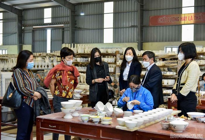 Chăm chú quan sát công nhân gia công các sản phẩm gốm gia dụng.