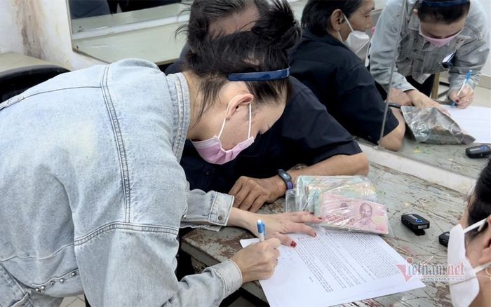 Thương Tín và vợ - chị Bùi Kim Chi - ký vào giấy cam kết sử dụng 244 triệu đồng đúng mục đích.