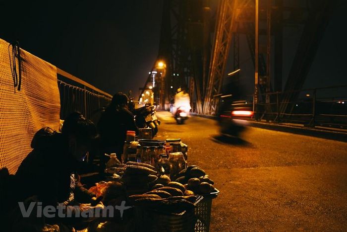  Một thú vui khác của giới trẻ mùa Đông Hà Nội là hóng gió trên cầu Long Biên, nghe thì có vẻ lạ nhưng quả thực những cơn gió lùa càng làm mùa đông nơi này trở nên thích thú hơn. Dừng lại ở quán cóc trên cầu, vừa nhâm nhi bắp ngô nướng vừa tận hưởng không khí trong lành và những con gió mang theo cái lạnh luồn qua thật là một trải nghiệm đáng có. (Ảnh: Hoài Nam/Vietnam+) 