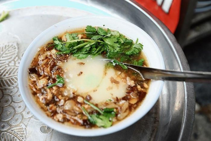 Còn gì bằng khi được thưởng thức bát bánh đúc nóng với hương vị đậm đà của nước mắm, thịt băm hòa quyện cùng bột bánh, thoang thoảng hương thơm của rau mùi với hành phi thơm lừng. (Ảnh: Hoài Nam/Vietnam+) 