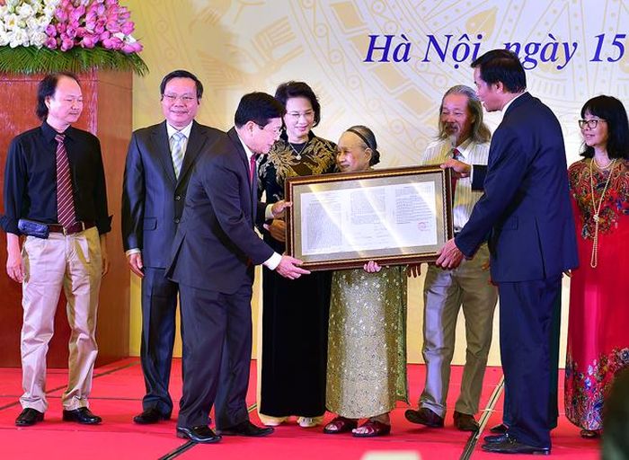 Đại diện gia đình cố nhạc sĩ Văn Cao trao văn bản hiến tặng tác phẩm “Tiến quân ca”. Ảnh: VGP/Nhật Bắc