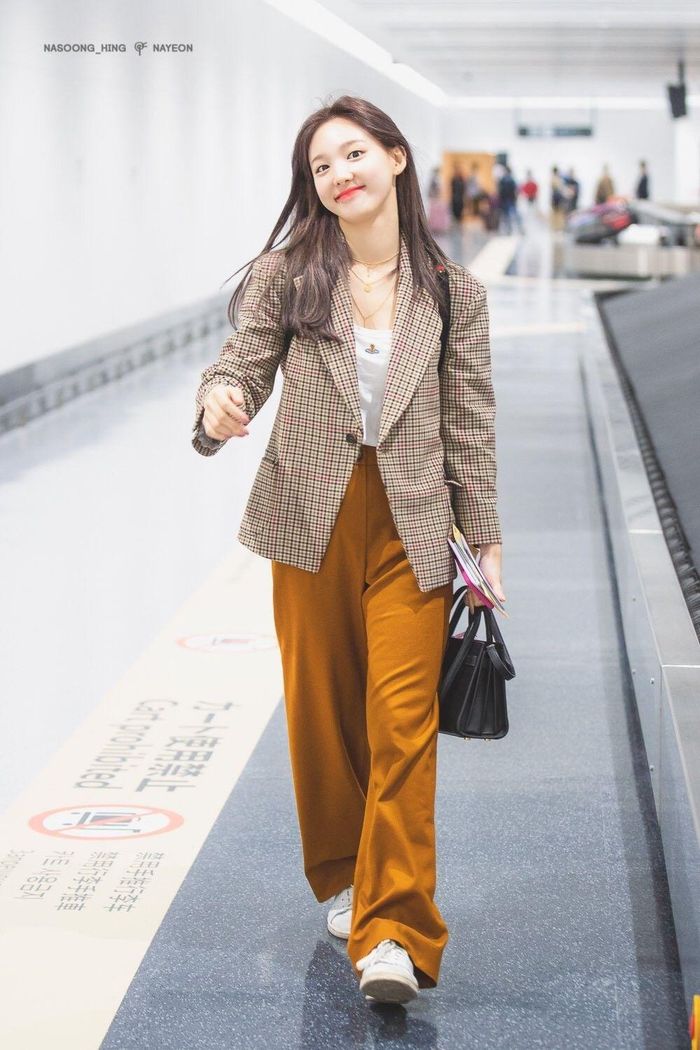 Combo áo thun trắng blazer kẻ quần âu vàng mù tạt và sneaker trắng của Nayeon rất đáng ghim vào cẩm nang mặc đẹp. Outfit này có rất nhiều ưu điểm, đó là sự trẻ trung, thanh lịch, tôn dáng tốt.