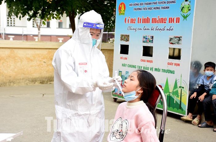 Cán bộ y tế lấy mẫu học sinh trường Tiểu học Hưng Thành (TP Tuyên Quang).
