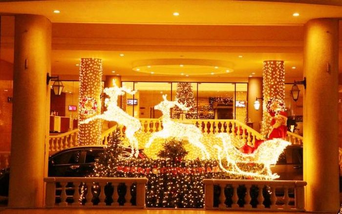 Ông già Noel và những chú tuần lộc lung linh trước cửa một khách sạn tại Thành phố Hồ Chí Minh. Ảnh: Thu Hương - TTXVN