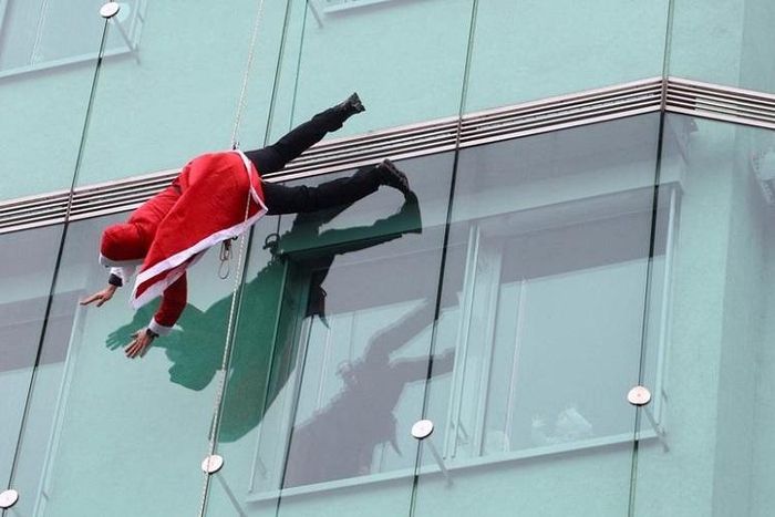 Một ông già Noel đu người ngoài tòa nhà cao tầng ở Ljubljana, Slovenia. Ảnh: Reuters