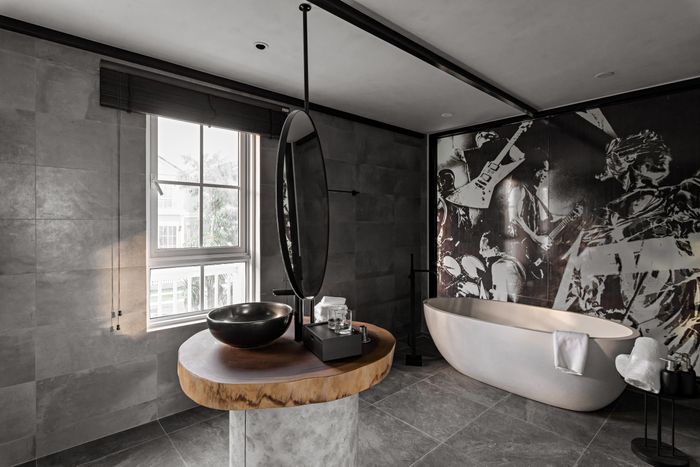 Phòng tắm rộng rãi chia thành 2 khu vực hoa sen và bồn riêng biệt, ngăn cách bởi đảo lavabo cách điệu.