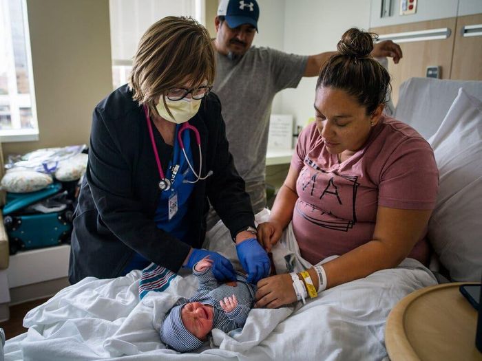  Vợ chồng Amanda Ramos và Chris Mejia bên cạnh đứa con mới sinh Mateo Chris Mejia. Ảnh: New York Times. 