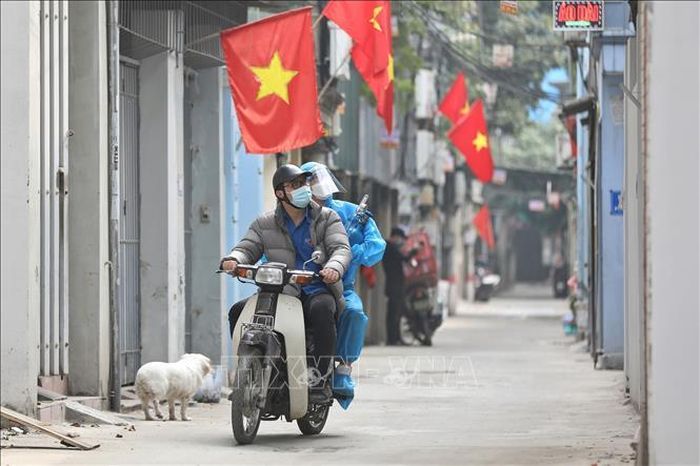 Thành viên Tổ hỗ trợ theo dõi người mắc COVID-19 tại nhà ở phường Lĩnh Nam được trang bị đồ bảo hộ, chở oxy bằng xe máy đến tận nhà người bệnh. Việc sử dụng "ATM Oxy" là hoàn toàn miễn phí.