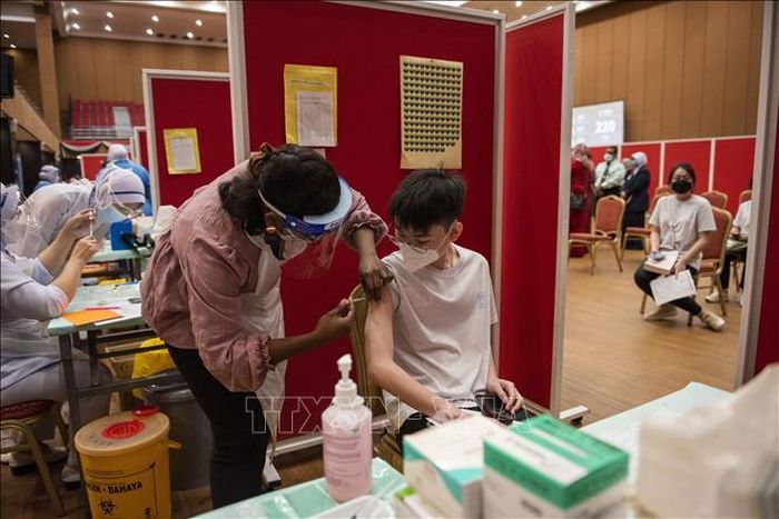 Nhân viên y tế tiêm vaccine phòng COVID-19 cho thiếu niên tại Shah Alam, bang Selangor, Malaysia. Ảnh: THX/TTXVN