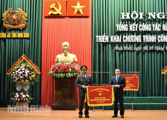 Đồng chí Phạm Quang Ngọc, Phó Bí thư Tỉnh ủy, Chủ tịch UBND tỉnh Ninh Bình trao Cờ thi đua xuất sắc của UBND tỉnh cho Công an tỉnh Ninh Bình.