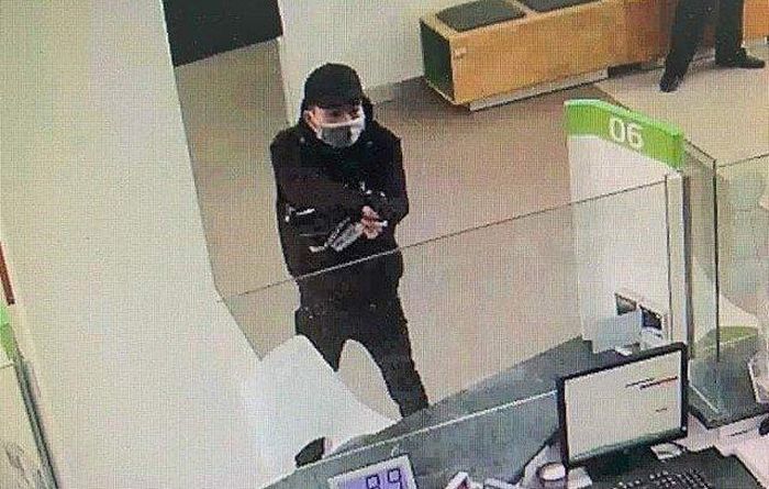 Tên cướp dùng vật giống súng uy hiếp nhân viên ngân hàng để cướp tiền. Ảnh: Cắt camera ngân hàng.