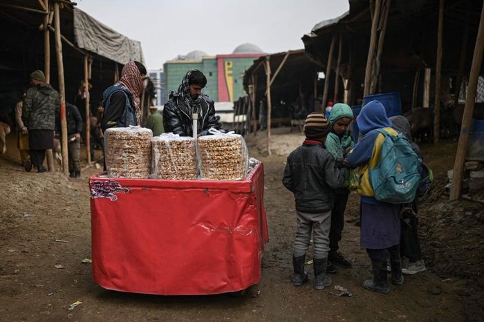 Một người bán đồ ngọt tại chợ gia súc ở Kabul. Ảnh: Mohd Rasfan / AFP.