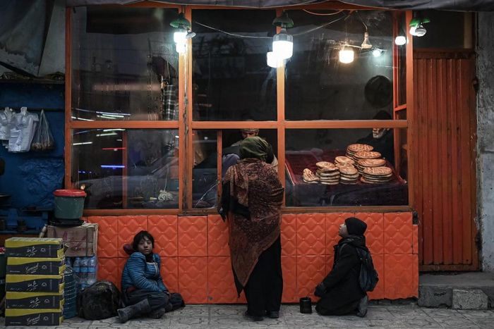 Một vài bé trai xin ăn tại một cửa hàng bánh mì ở Kabul. Ảnh: Mohd Rasfan / AFP.