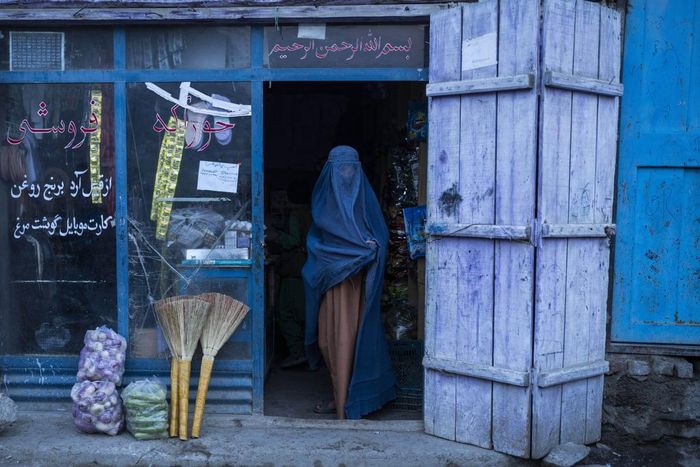 Một người phụ nữ rời cửa hàng tiện lợi ở Kabul. Ảnh: Petros Giannakouris / AP.