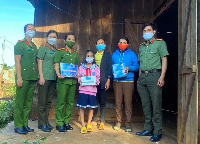 Đại úy Lãnh (phải) cùng cán bộ chiến sĩ công an trao tặng máy tính cho học sinh khó khăn