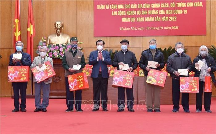 Bí thư Thành ủy Hà Nội Đinh Tiến Dũng trao quà cho các gia đình chính sách, đối tượng khó khăn, lao động nghèo. Ảnh: TTXVN phát