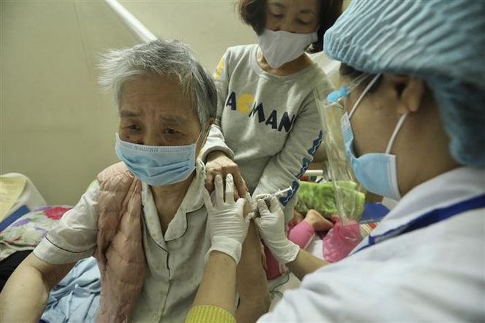 Tiêm vaccine phòng COVID -19 mũi 3 cho người dân. Ảnh: TTXVN