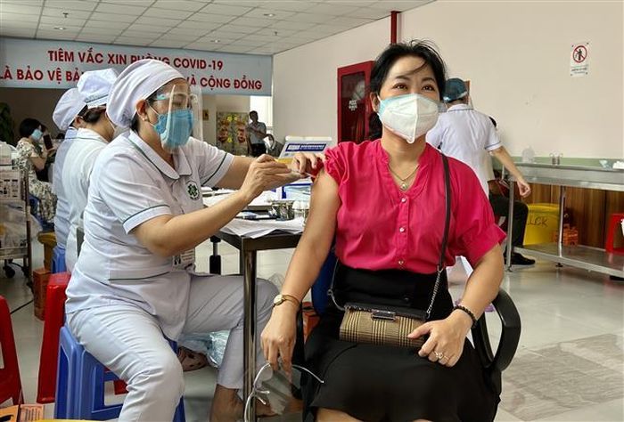 Tiêm vaccine phòng COVID -19 mũi 3 cho người dân. Ảnh: TTXVN