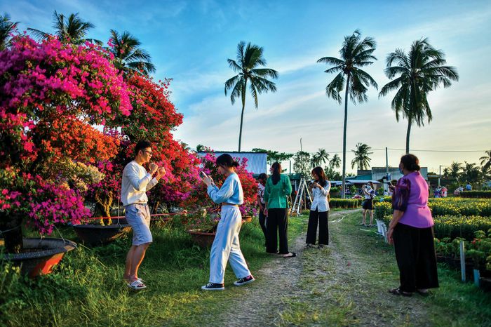 Các bạn trẻ đến chụp hình lưu niệm tại làng hoa.