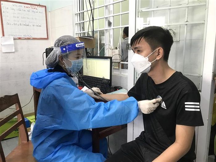 Nhân viên y tế khám sàng lọc trước khi tiêm vaccine mũi 3 cho người dân tại Trạm y tế xã Phú Đức, huyện Long Hồ, tỉnh Vĩnh Long. Ảnh: Lê Thúy Hằng – TTXVN