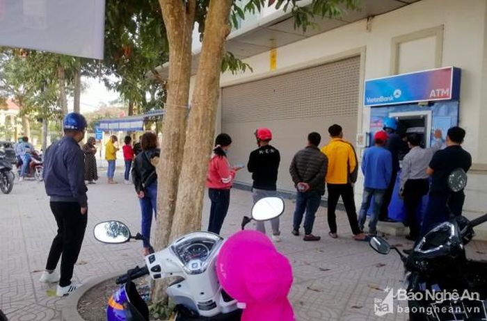 Tại thị trấn Yên Thành cũng xẩy ra tình trạng tương tự trong sáng 29/1, mỗi cây ATM đều có hàng dài người rồng rắn chờ rút tiền. Thậm chí có nhiều người mất cả buổi sáng chỉ để rút tiền Tết. Ảnh: Quang An