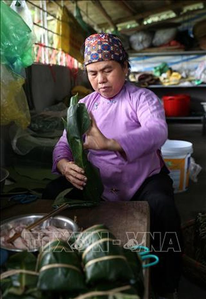 Đồng bào dân tộc người Dáy (Lào Cai) gói bánh chưng đen chuẩn bị đón Tết.
