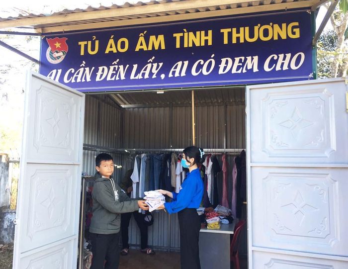Thành viên đội thanh niên xung kích Trường THPT Phạm Văn Đồng (huyện Ia Grai) trao áo quần cho người dân. Ảnh: Thủy Bình