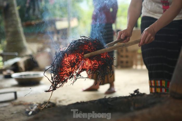 Để giữ được tro tốt, người dân sẽ gắp những đống tro còn đỏ ửng vào trong chiếc cối đã đong sẵn gạo nếp.