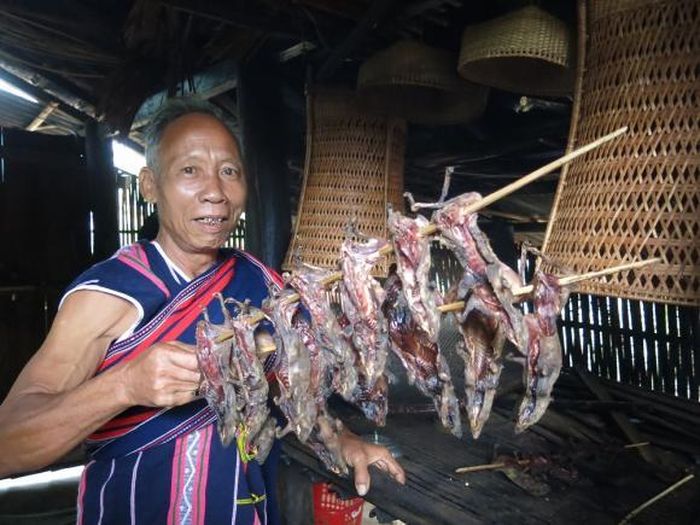 Già làng chuẩn bị món thịt xông khói đãi khách