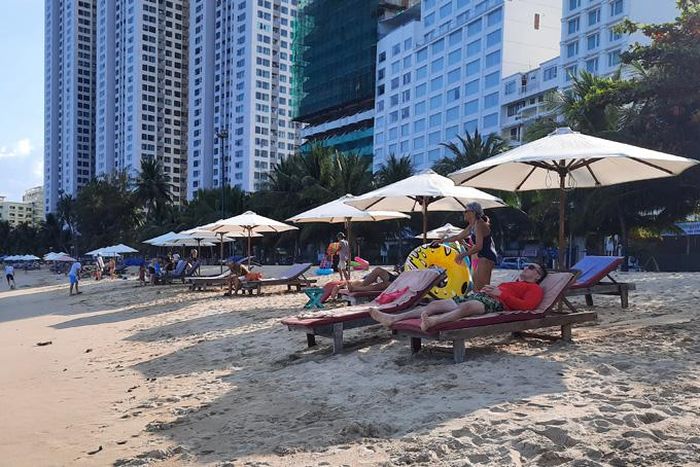 Du khách thư giãn trên bãi biển, đoạn gần khu vực Hòn Chồng.